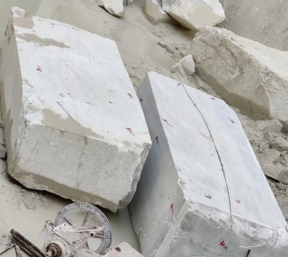 A raw marble block awaiting hand selection in the SAV Stonex yard